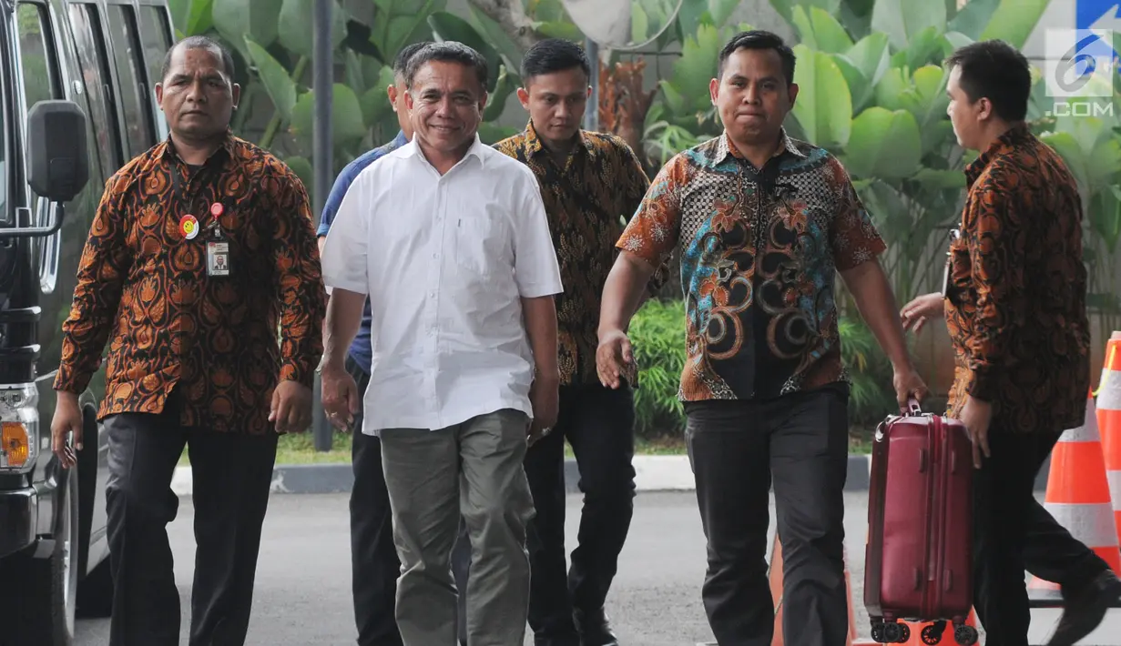 Gubernur Aceh Irwandi Yusuf dengan pengawalan petugas tiba di Gedung KPK, Jakarta, Rabu (4/7). Irwandi hanya melempar senyum dan tak menggubris saat ditanya dugaan suap sekitar Rp500 juta yang dirinya terima. (Merdeka.com/Dwi Narwoko)