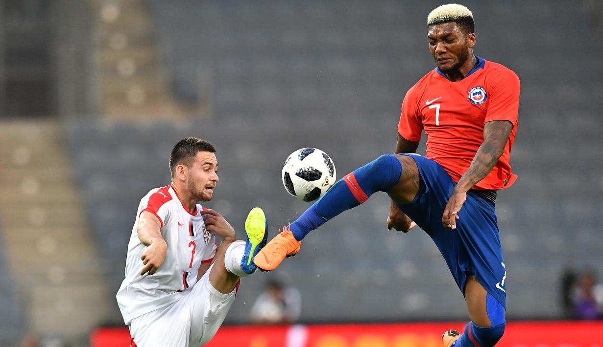 Pemain Serbia, Andrija Zivkovic (kiri) dan pemain Chili,  Junior Fernandes berebut bola pada laga uji coba di Merkur Arena, Graz, Austria, (4/6/2018).  Serbia kalah dari Chili 0-1. (AFP/Joe Klamar)
