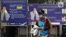 Calon penumpang KA jarak jauh melintas di depan papan panduan melakukan tes GeNose COVID-19 di Stasiun Pasar Senen, Jakarta, Sabtu (1/5/2021). PT Kereta Api Indonesia (Persero) membatasi masa berlaku hasil tes GeNose C19 menjadi 1x24 jam mulai Kamis (1/4) lalu. (Liputan6.com/Helmi Fithriansyah)