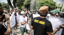 Sejumlah musisi kafe saat melaksanakan aksi di depan Balai Kota Jakarta, Rabu (8/7/2020). Aksi ngamen di depan Balai Kota Jakarta yang diikuti oleh musisi kafe itu untuk menyuarakan aspirasi pekerja seni harian yang terdampak mata pencahariannya selama masa PSBB. (Liputan6.com/Faizal Fanani)