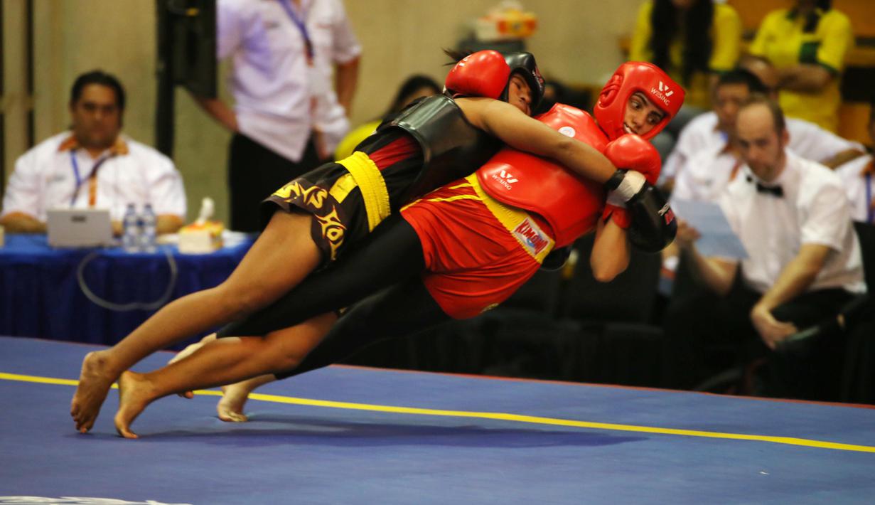 Atlet wushu Indonesia, Moria Manalu (kiri), membanting lawannya asal Turki, Nagihan Kalyoncu di kelas Sanda Wanita 60 kg pada Kejuaraan Dunia Wushu 2015 di Istora Gelora Bung Karno, Senayan, Jakarta, Senin (16/11/2015). (Bola.com/Nicklas Hanoatubun)