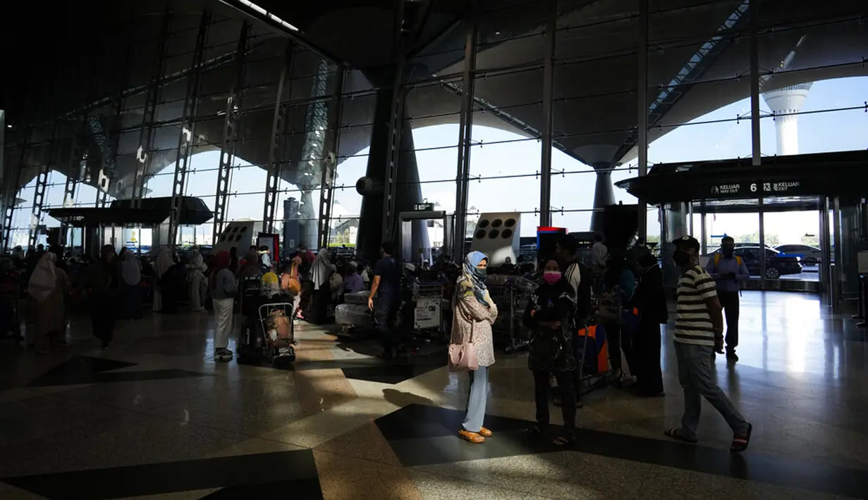 Pelancong mengantre untuk check-in di Bandara Internasional Kuala Lumpur, Sepang, Malaysia, Jumat (1/4/2022). Mulai hari ini, Malaysia membuka perbatasannya untuk orang asing dan pelancong yang sudah divaksin COVID-19 lengkap tanpa harus menjalani karantina. (AP Photo/Vincent Thian)