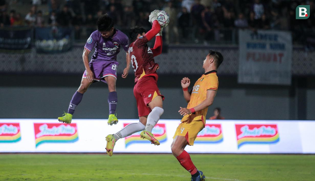 <p>Kiper Persik kediri, Muhammad Adi Satryo (tengah) berusaha mengamankan bola saat laga pekan pertama BRI Liga 1 2022/2023 antara Persita Tangerang melawan Persik Kediri di Indomilk Arena, Tangerang, Senin (25/07/2022). (Bola.com/Bagaskara Lazuardi)</p>