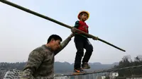 Aksi ekstrem yang dilakukan seorang bocah China dengan meniti seutas tali pada ketinggian tertentu membuat banyak orang kagum.