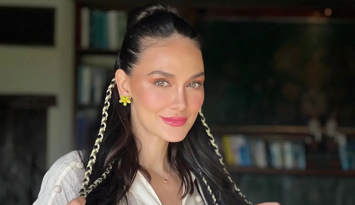 Rambut panjangnya diikat setengah dan di beberapa bagian rambutnya dikepang kemudian dihiasi dengan pita, tatanan rambut Luna Maya makin unik. Anting bentuk bunga berwarna kuning yang dipakainya mendukung penampilannya di acara ultah agar semakin mencuri perhatian. Polesan makeup flawless dan lipstik berwarna merah muda sangat cocok dengan Luna Maya yang sedang rayakan hari bahagianya. (Liputan6.com/IG/@hairbyranggayusuf)