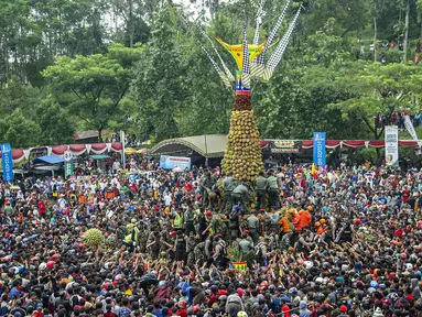 Ribuan pengunjung berebut gunungan durian saat festival Kenduren di Jombang, Jawa Timur, Minggu (3/3). Festival tersebut merupakan acara tahunan yang digelar setiap memasuki musim panen durian sebagai bentuk syukur petani kepada Tuhan (Juni Kriswanto/AFP)