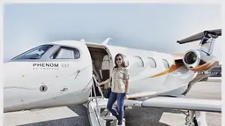 Berpose di tangga sebuah pesawat jet, Maia Estianty tampak santai. Dengan kemeja berwarna krem dan celana jeans, penampilannya semakin lengkap dengan beberapa aksesoris seperti jam tangan, tas sandang hitam, dan kacamata hitam. (Liputan6.com/IG/@maiaestiantyreal)
