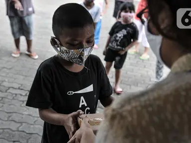 Seorang anak menerima donasi ponsel yang diberikan oleh Komunitas #WartawanLintasMedia saat acara #PonselPintarUntukPelajar di Jakarta, Minggu (9/8/2020). (merdeka.com/Iqbal S. Nugroho)