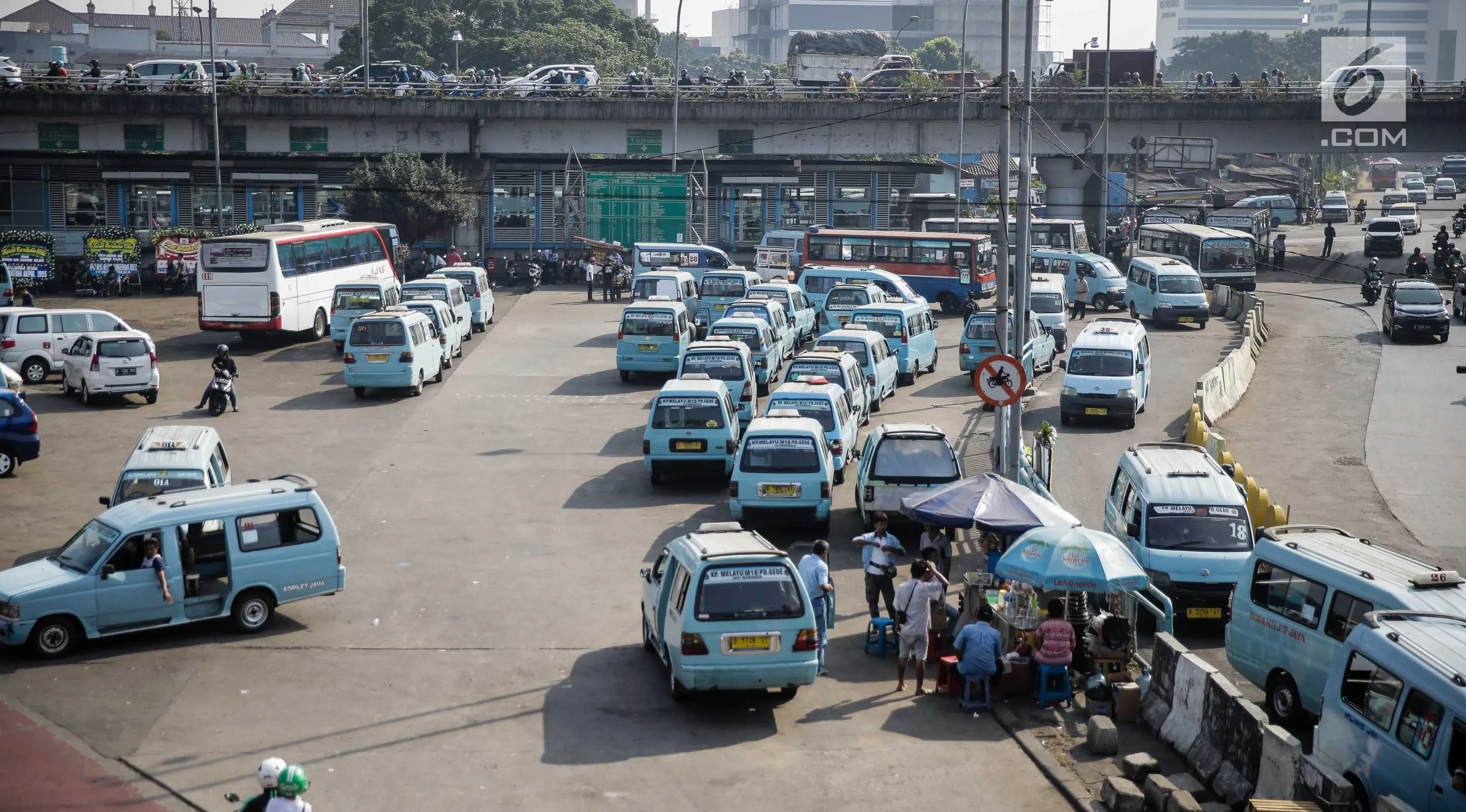 Puluhan angkutan umum (angkot) menunggu penumpang di Terminal Kampung Melayu Jakarta, Jumat (26/5). Setelah sempat berhenti beroperasi pasca-bom Rabu (24/5) lalu, Terminal Kampung Melayu kembali dibuka dan dioperasikan. (Liputan6.com/Faizal Fanani)