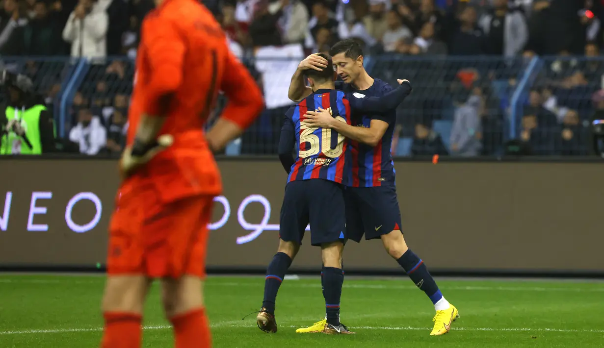 Penyerang Barcelona, Robert Lewandowski (kanan) berselebrasi dengan rekannya Gavi selama pertandingan final Piala Super Spanyol di Stadion King Fahd, di Riyadh, Arab Saudi, Senin (16/1/2023). Barcelona menjadi juara setelah berhasil mengalahkan Real Madrid 3-1 pada laga final, Minggu (16/1) dini hari WIB. (AFP/Fayez Nureldine)