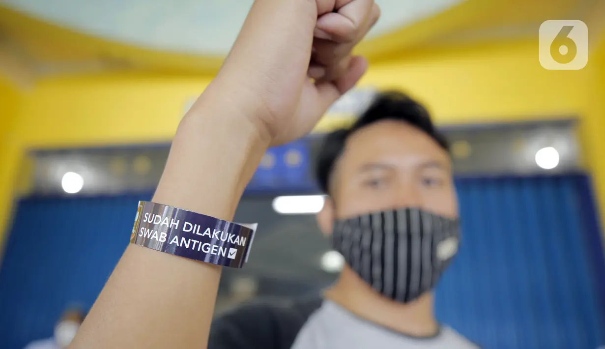 Seorang panitia pelaksana menunjukkan gelang tanda sudah melakukan swab antigen jelang pertandingan sepak bola Piala Menpora 2021 di Stadion Kanjuruhan, Malang, Jawa Timur, Senin (22/3/2021). (Bola.com/Arief Bagus)