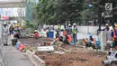 Pekerja menyelesaikan jalur pedestrian di Jalan Sudirman, Jakarta, Senin (2/7). Perbaikan jalur pedestrian di sepanjang koridor Jalan Sudirman menjadi porsi pekerjaan PT MRT Jakarta, ditargetkan selesai pada 31 Juli 2018. (Liputan6.com/Arya Manggala)