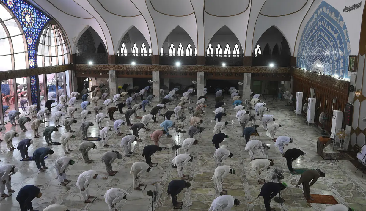 Umat muslim menerapkan jaga jarak aman atau physical distancing saat melaksanakan salat Jumat berjemaah selama Ramadan di Masjid Data Darbar, Lahore, Pakistan, Jumat (1/5/2020). Umat muslim dunia melaksanakan Ramadan tahun ini di tengah pandemi COVID-19. (ARIF ALI/AFP)