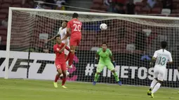 Bek Timnas Indonesia, RIcky Fajrin, duel udara dengan gelandang Singapura, Ikhsan, pada laga Piala AFF di Stadion Nasional, Singapura, Jumat (9/11). Singapura menang 1-0 atas Indonesia. (Bola.com/M. Iqbal Ichsan)