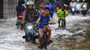 Anak-anak mengendarai sepeda melintasi banjir yang merendam Jalan Benteng,  Duta Kranji, Kalibaru, Bekasi, Jawa Barat, Jumat (24/2/2023). Jalan yang dilalui oleh para pengendara masih digenangi air ditambah dari luapan kalibaru Duta Kranji akibat hujan deras yang mengguyur Kota Bekasi sejak Kamis (23/2/2023) malam. (merdeka.com/Imam Buhori)