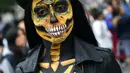 Seorang wanita berpakaian seperti "Catrina" ambil bagian dalam parade Hari Orang Mati di Reforma Avenue, Mexico City, 21 Oktober 2018. Hari kematian ini jadi hari libur nasional di negara-negara Amerika Latin, khususnya Meksiko. (RODRIGO ARANGUA/AFP)