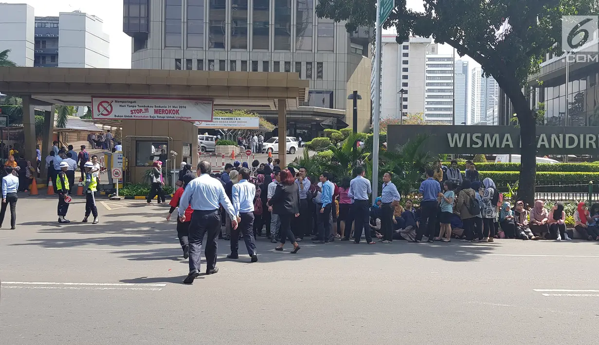Sejumlah karyawan berhamburan keluar gedung setelah terjadinya gempa di kawasan Jalan MH Thamrin, Jakarta, Selasa (23/1). BMKG menyebut gempa yang menggoyang Jakarta berpusat di Lebak Banten dengan besar 6,4 Magnitudo. (Liputan6.com/Herman Zakharia)