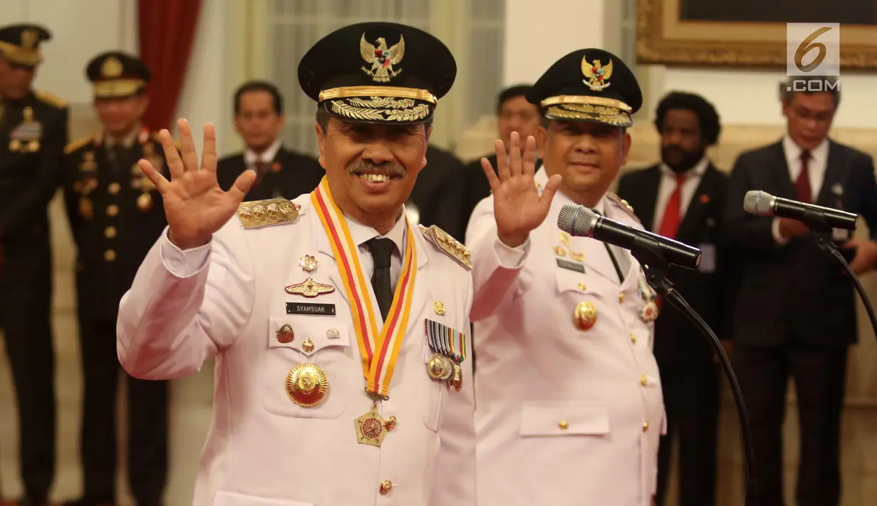 Syamsuar (kiri) dan Edy Natar Nasution melambaikan tangan saat pelantikan sebagai Gubernur dan Wakil Gubernur Riau periode 2019-2024 di Istana Negara, Jakarta, Rabu (20/2). (Liputan6.com/Angga Yuniar)