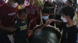 Warga memukul bedug saat takbiran di Jalan Kartini, Sawah Besar, Jakarta, Rabu (12/5/2021) malam. Warga DKI Jakarta dilarang melakukan takbiran keliling pada malam Idul Fitri 1442 Hijriah. (Liputan6.com/Herman Zakharia)