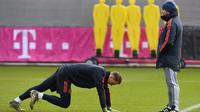 Kiper Bayern Munchen Manuel Neuer (kiri) melakukan pemanasan dekat pelatih Hansi Flick saat sesi latihan di Munich, Jerman, Selasa (10/12/2019). Bayern Munchen akan menghadapi Tottenham Hotspur pada pertandingan Grup B Liga Champions. (Christof STACHE/AFP)