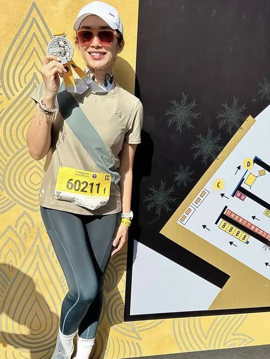 Ussy Sulistiawaty pun memamerkan medalinya. Ia tampil dengan kaos hijau dipadukan celana ketat panjang hitam. Ia mengenakan sepatu lari putih dan kaos kaki serasi dengan topinya. [@ussypratama]