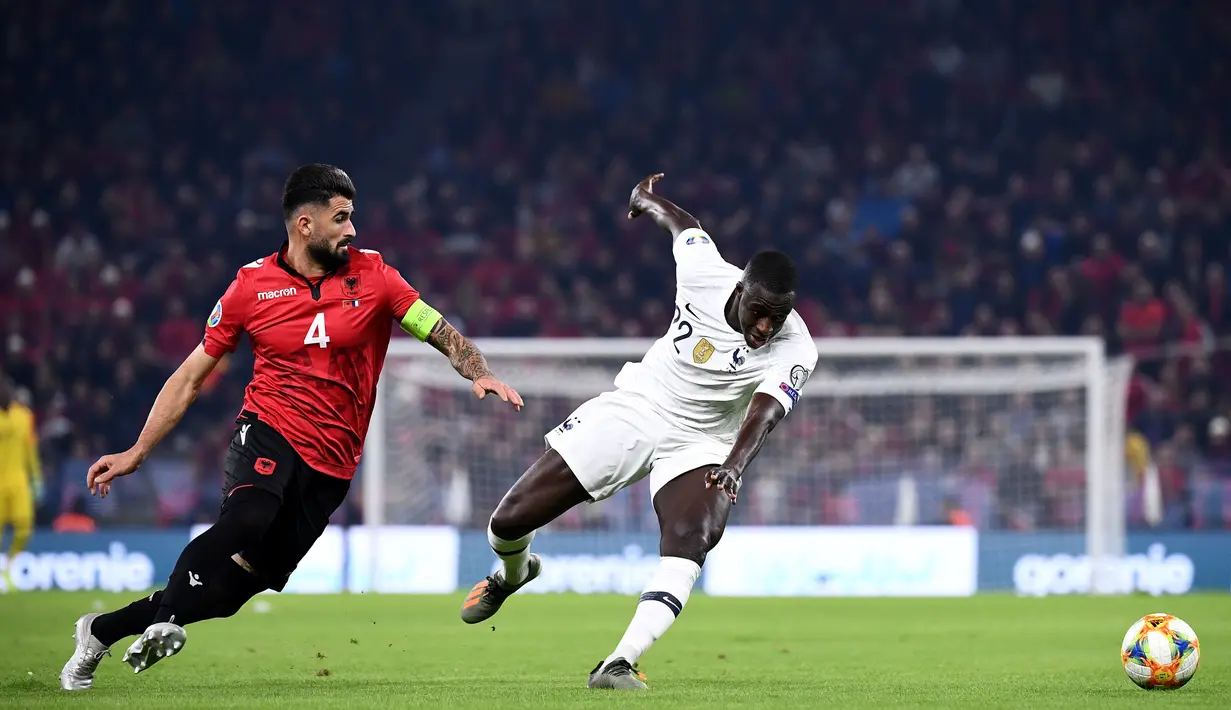 Bek Timnas Prancis,  Benjamin Mendy berebut bola dengan bek Albania Elseid Hysaj pada kualifikasi Grup H Piala Eropa 2020 di Arena Kombetare, Minggu (17/11/2019). Prancis menutup babak kualifikasi Piala Eropa 2020 dengan kemenangan setelah menekuk Albania 2-0. (FRANCK FIFE / AFP)