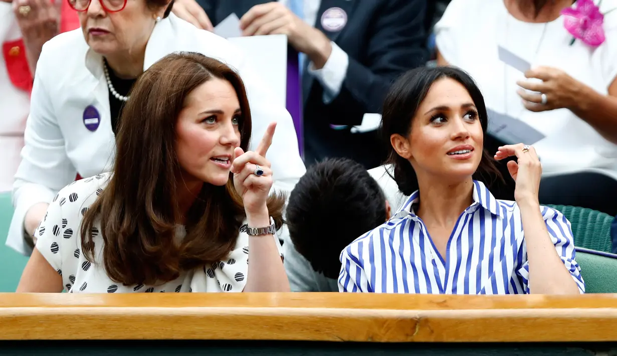 Duchess of Cambridge Kate Middleton dan Duchess of Sussex Meghan Markle berbincang saat menyaksikan pertandingan tenis dalam Kejuaraan Wimbledon di London, Inggris, (14/7). (AP Photo/Nic Bothma)