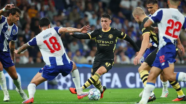 Pemain Manchester City Phil Foden (tengah) berusaha menggiring bola melewati pemain Porto Nehuen Perez