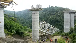 Gantri tersebut runtuh di sebuah jembatan di Sairang, sebuah kota di pinggiran Aizawal, ibu kota negara bagian Mizoram, menurut ruang kendali polisi. Jembatan ini telah dibangun selama hampir dua tahun. (AFP Photo)