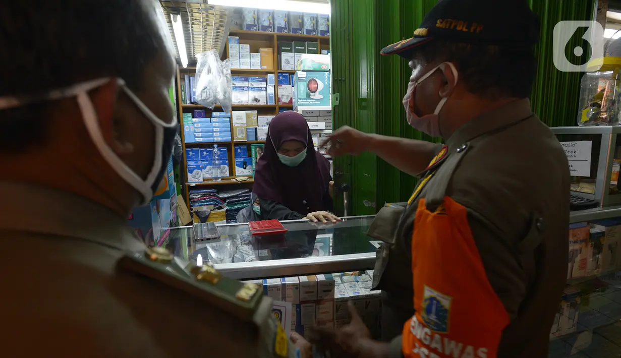 Petugas gabungan melakukan razia pertokoan dan tempat makan di Pasar Pramuka, Jakarta, Kamis (24/9/2020). Upaya mencegah penularan virus corona terus dilakukan dengan merazia penggunaan masker dan tempat usaha makan yang masih melayani makan di tempat. (merdeka.com/Imam Buhori)