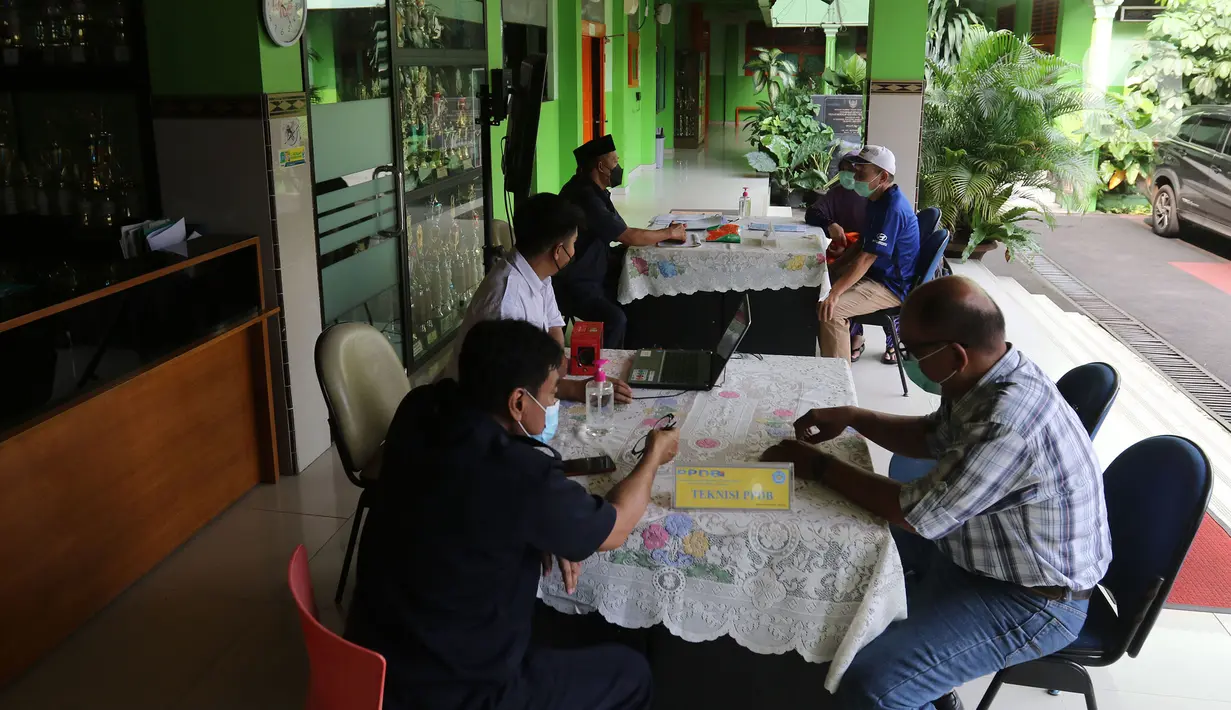 Orang tua murid mencari informasi pengajuan akun untuk mengikuti proses Penerimaan Peserta Didik Baru (PPDB) Tahun Pelajaran 2021/2022 di SMA Negeri 87 Jakarta, Senin (7/6/2021).  Proses PPDB DKI Jakarta yang mulai dibuka sejak hari ini, Senin (7/6). (Liputan6.com/Herman Zakharia)