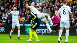 Striker Arsenal, Olivier Giroud, berebut bola dengan bek Swansea, Federico Fernandez. Meriam London menguasai jalannya laga dengan penguasaan bola 57 persen dan melakukan enam kali tembakan ke arah gawang. (EPA/Aled Llywelyn)