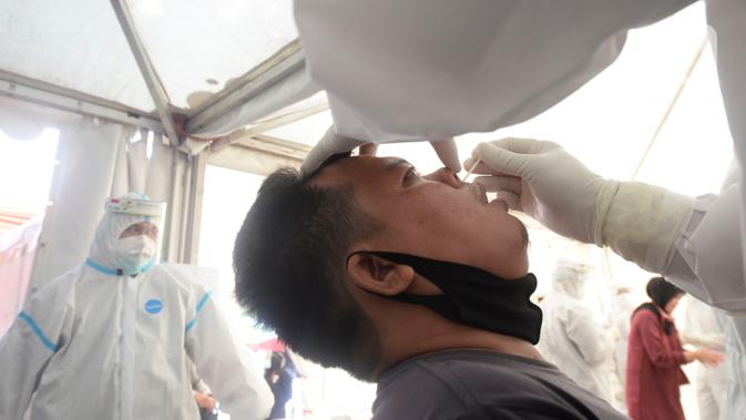 Petugas medis mengambil sempel lendir salah satu peserta test SWAB massal gratis di halaman Dinas Kesehatan Tangeramg Selatan, Banten, Minggu (30/8/2020). Test Swab gratis tersebut diikuti 750 orang untuk pencegahaan penyebaran Covid-19. (merdeka.com/Dwi Narwoko)