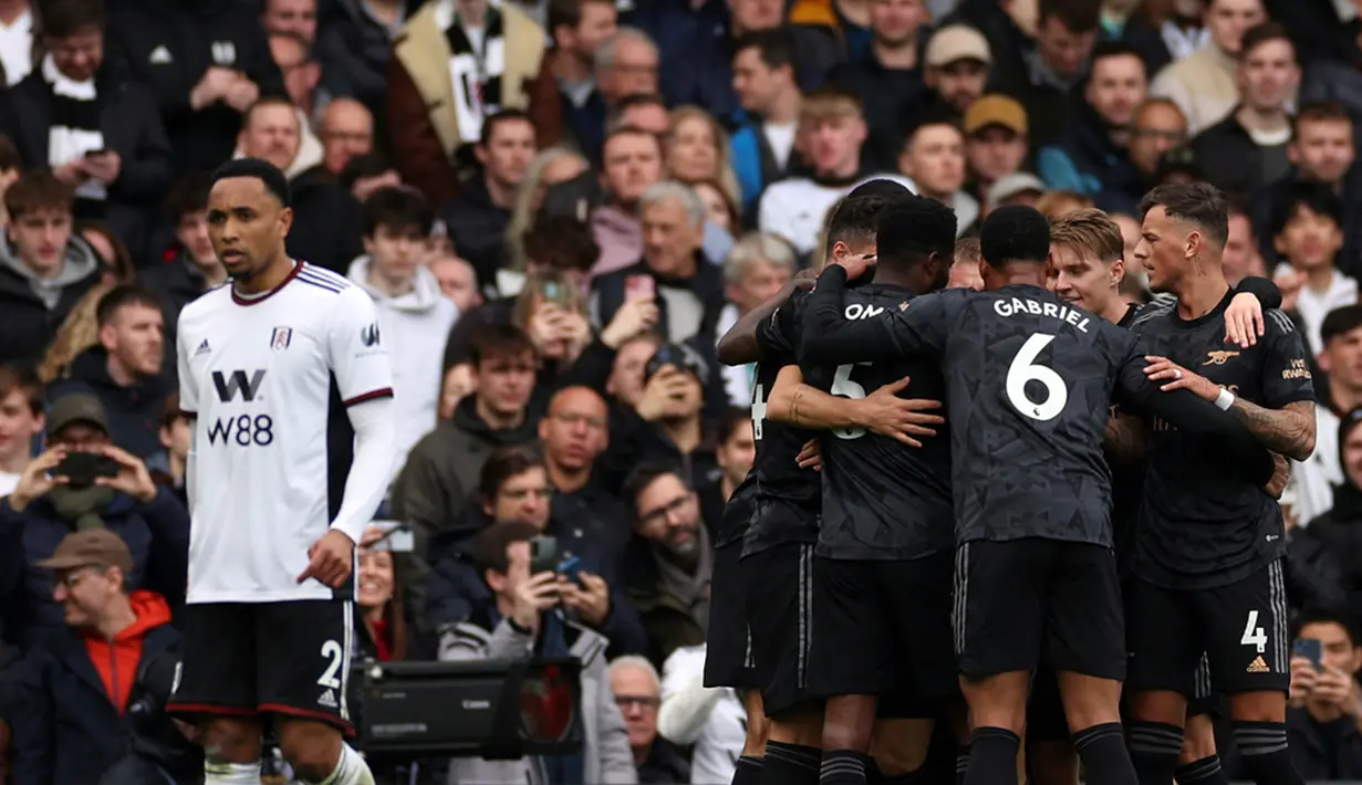 Para pemain Arsenal merayakan setelah pemain Fulham Antonee Robinson mencetak gol bunuh diri melewati kipernya pada pertandingan sepak bola Liga Inggris di Stadion Craven Cottage, London, 12 Maret 2023. Arsenal mengalahkan Fulham dengan skor 3-0. (AP Photo/Ian Walton)
