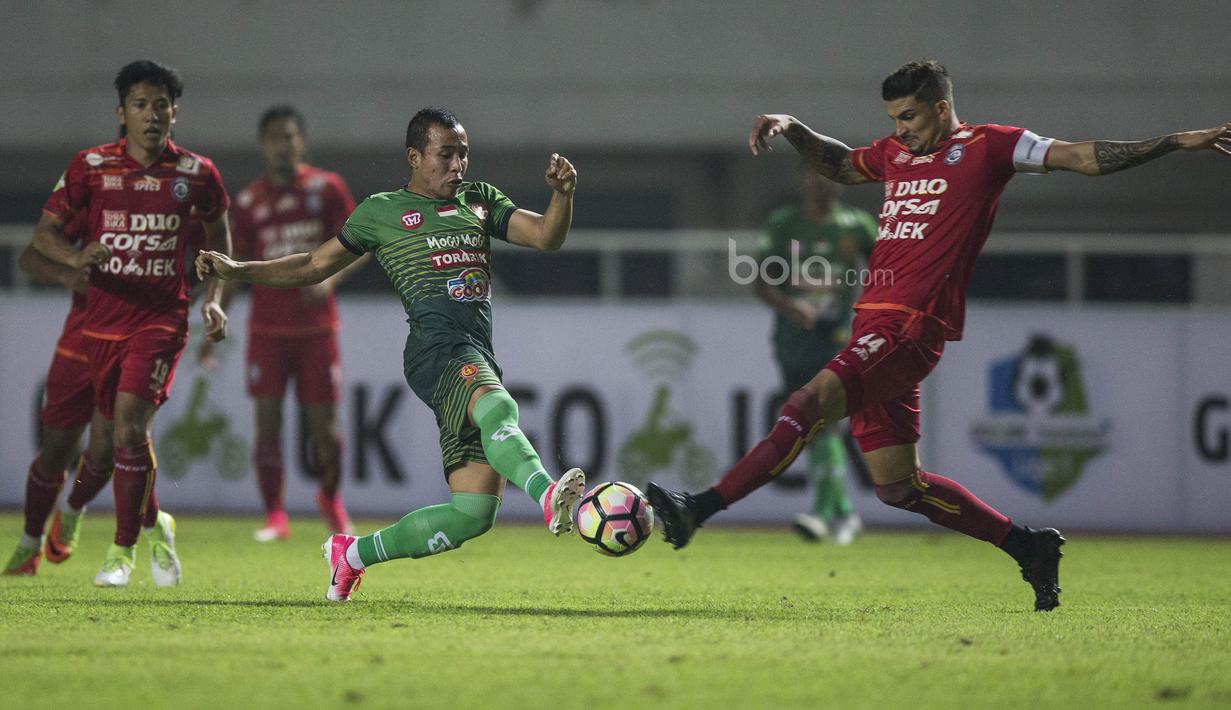 Bek Arema FC, Arthur Cunha, berebut bola dengan gelandang PS TNI, Guntur Triaji, pada laga Liga 1 di Stadion Pakansari, Bogor, Senin (3/7/2017). Kedua klub bermain imbang 0-0. (Bola.com/Vitalis Yogi Trisna)