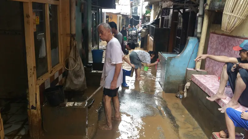 Warga korban banjir di Kampung Melayu mulai membersihkan rumah dari lumpur.