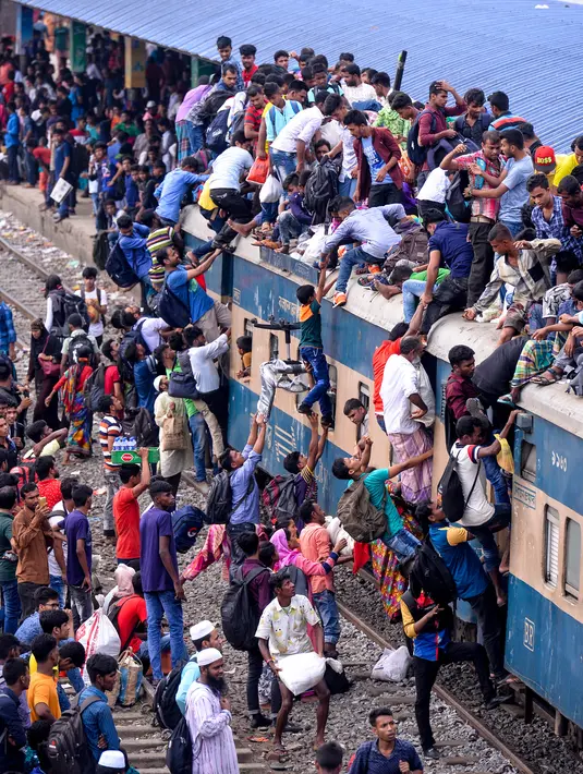 Ratusan orang berupaya menaiki atap kereta api untuk menuju kampung halaman di Dhaka, Bangladesh pada 4 Juni 2019. Pemadangan mencengangkan dari ratusan yang naik dan duduk di atas kereta karena gerbong yang penuh terlihat pada menjelang Idul Fitri di Bangladesh. (MUNIR UZ ZAMAN/AFP)