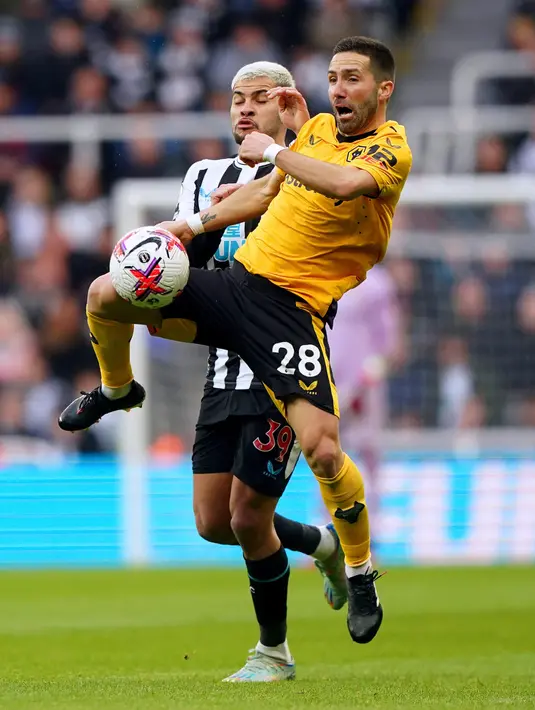 Pemain Newcastle United Bruno Guimaraes (kiri) bertarung memperebutkan bola dengan pemain Wolverhampton Wanderers Joao Moutinho pada pertandingan sepak bola Liga Inggris di St. James' Park, Newcastle, Inggris, 12 Maret 2023. Newcastle United mengalahan Wolverhampton Wanderers dengan skor 2-1. (Owen Humphreys/PA via AP)