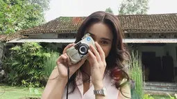 Tidak hanya kamera DSLR, kamera yang menggunakan roll film nyatanya juga menjadi kesukaan Michelle Ziudith saat memotret. Gaya kecenya saat memotret ini bikin jatuh hati para penggemarnya. (Liputan6.com/IG/@michelleziu)