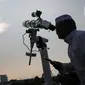 Petugas Masjid Al-Musyariin mengamati posisi hilal menggunakan teropong saat Rukyatul Hilal di Jakarta, Minggu (1/5/2022). Pemantauan hilal yang dilakukan menggunakan teropong tersebut memastikan Idul Fitri 1443 H jatuh pada 2 Mei 2022. (Liputan6.com/Faizal Fanani)