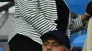 Pelatih Manchester United, Jose Mourinho memakai topi saat menyaksikan pertandingan Manchester City melawan Everton pada Liga Inggris di Stadion Etihad, (22/8). (AFP Photo/Anthony Devlin)