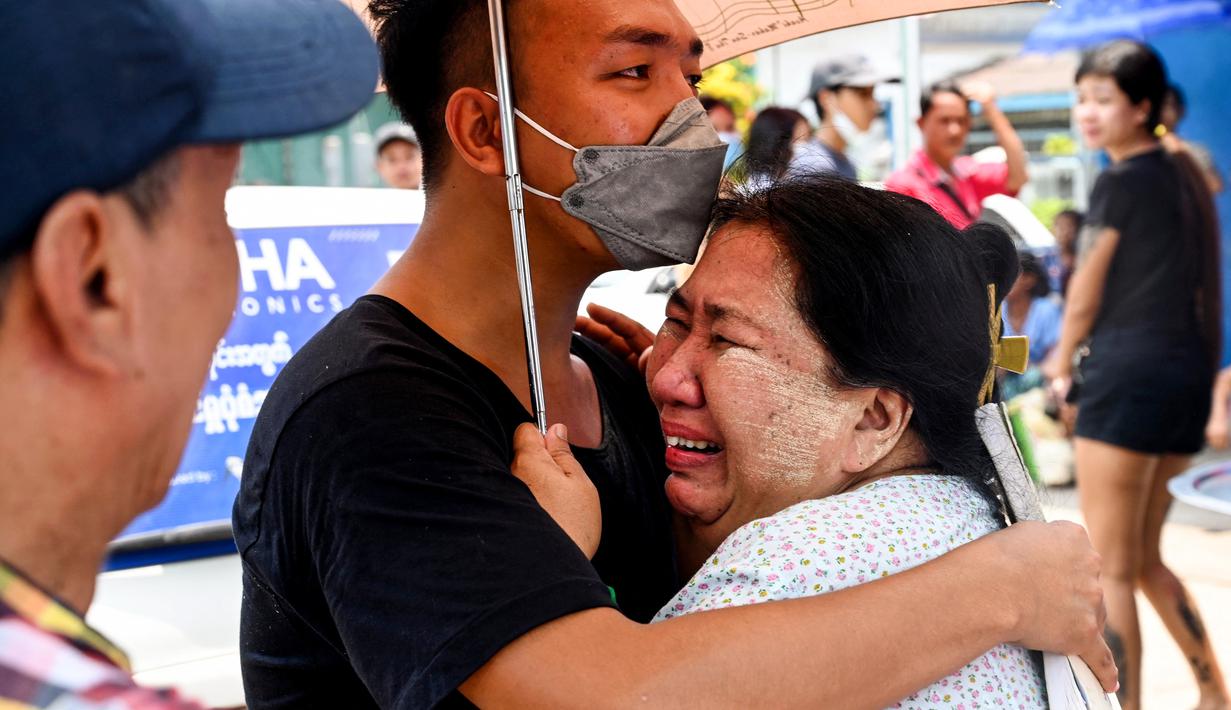 Seorang pria merayakan dengan seorang kerabatnya setelah dibebaskan dari Penjara Insein di Yangon pada 17 April 2023. (AFP/STR)