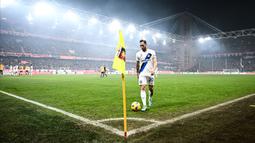 Pemain Inter Milan, Hakan Calhanoglu bersiap melakukan tendangan sepak pojok dengan latar stadion yang dipenuhi asap saat laga lanjutan Liga Italia 2023/2024 melawan Genoa di Stadion Luigi Ferraris, Genoa, Italia, Sabtu (30/12/2023) dini hari WIB. (AFP/Piero Cruciatti)