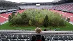 Pengunjung melihat instalasi ekosistem hutan di Stadion Woerthersee, Austria, Minggu (8/9/2019). Karya seni di salah satu stadion yang digunakan dalam ajang Piala Eropa 2008 ini diciptakan oleh seorang seniman asal Swiss bernama Klaus Litmann. (AP/Ronald Zak)