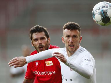 Gelandang Bayern Munchen, Ivan Perisic, berebut bola dengan pemain Union Berlin, Christopher Trimmel, pada laga Bundesliga  di Alte Foersterei, Minggu (17/5/2020). Bayern Munchen menang 2-0 atas Union Berlin. (AP/Hannibal Hanschke)