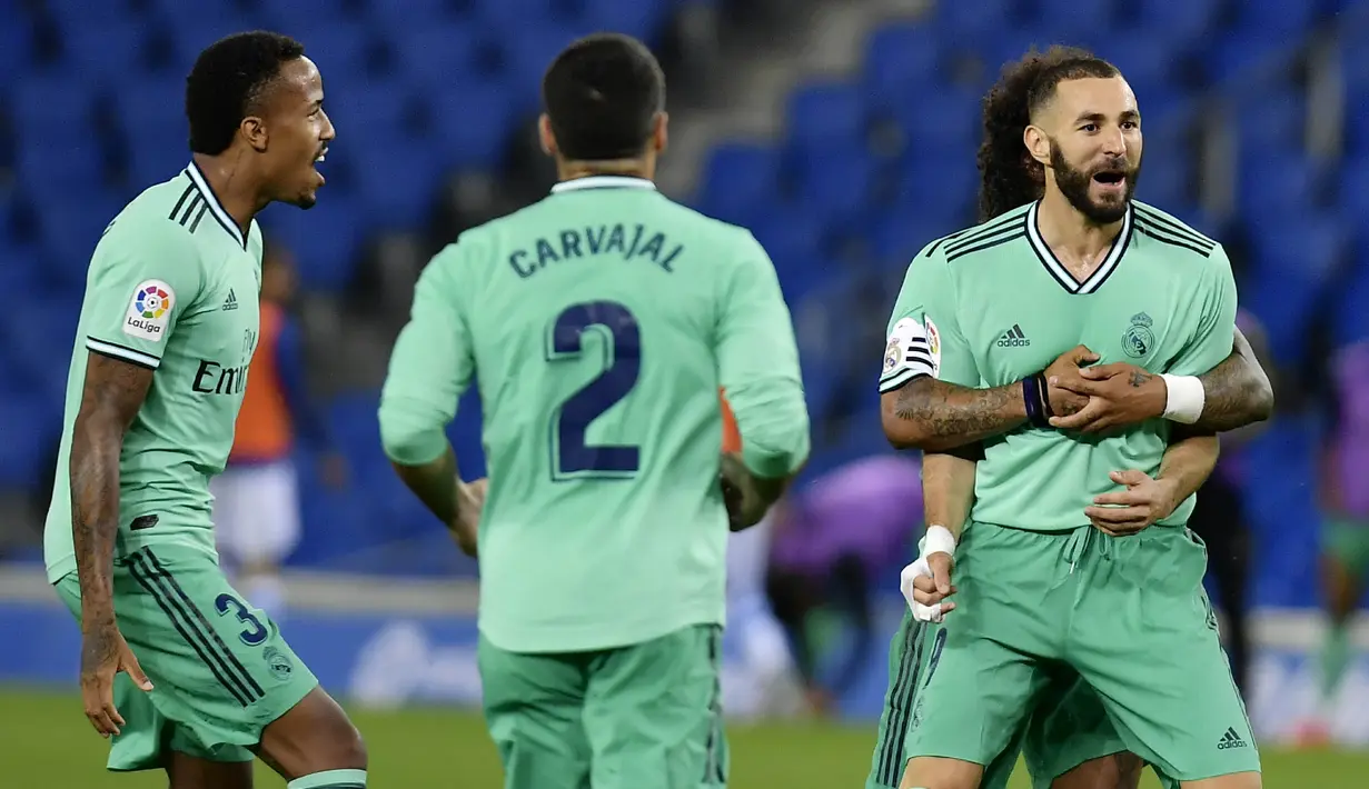 Para pemain Real Madrid merayakan gol yang dicetak oleh Karim Benzema ke gawang Real Sociedad pada laga La Liga di Reale Seguros Stadium, Minggu (21/6/2020). Real Madrid menang 2-1 atas Real Sociedad. (AP Photo/Alvaro Barrientos)