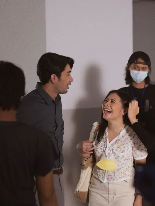 Terlihat sedang bercanda ria berdua, Prilly yang mengenakan atasan blouse putih bermotif bunga sedang tertawa memandangi Reza Rahardian yang tampil mengenakan kemeja formal berwarna abu-abu. Foto: Instagram.