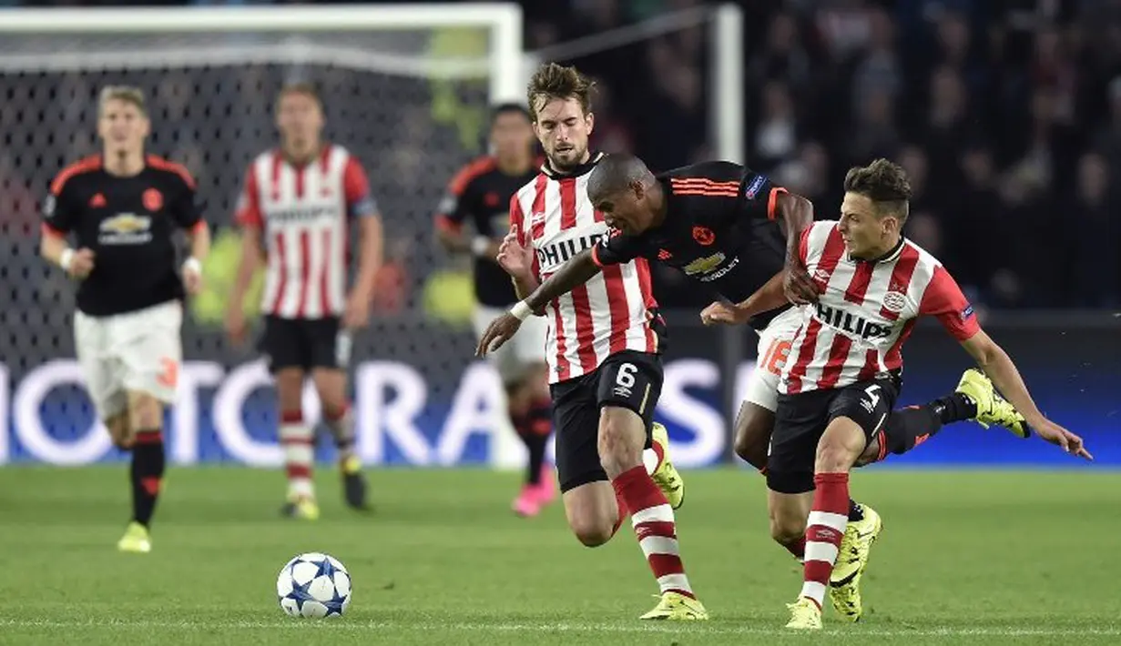 Pemain PSV,  Danny Propper (tengah) berebut bola dengan pemain MU,  Ashley Young, dalam pertandingan Grup B Liga Champions yang berlangsung di Stadion Philips, Eindhoven, Belanda. Selasa (12/9/2015). (AFP Photo/John Thys)
