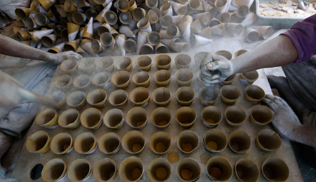Para pekerja menyiapkan bubuk mesiu untuk membuat petasan, di sebuah pabrik pinggiran  Ahmadabad, Senin (22/10). Permintaan petasan di India semakin meningkat jelang perayaan Festival "Cahaya" Diwali bagi umat Hindu. (AP/Ajit Solanki)