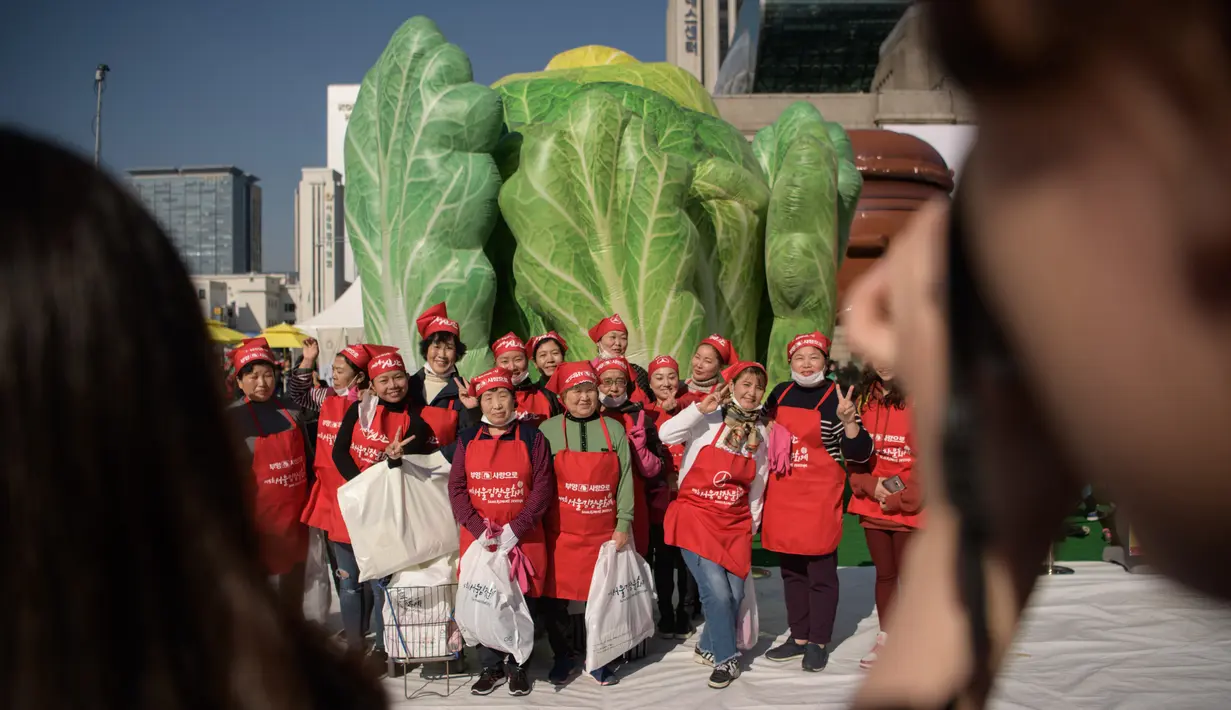 Peserta berpose bersama selama berpartisipasi dalam festival pembuatan kimchi di Seoul (2/11). Hidangan tradisional berupa kubis yang difermentasi dan lobak ini hasilnya akan didonasikan untuk kaum minoritas di Korsel.  (AFP Photo/Ed Jones)